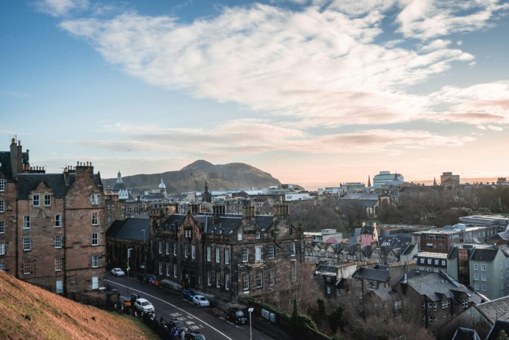 Captivating view of Edinburgh's historic skyline with Arthur's Seat in the background at sunset.